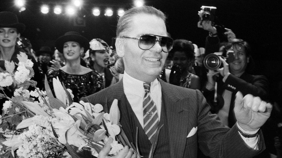 March 27, 1984 German fashion designer Karl Lagerfeld, flanked with models, acknowledges the public after the Chanel autumn-winter 1984/1985 ready-to-wear collection show in Paris