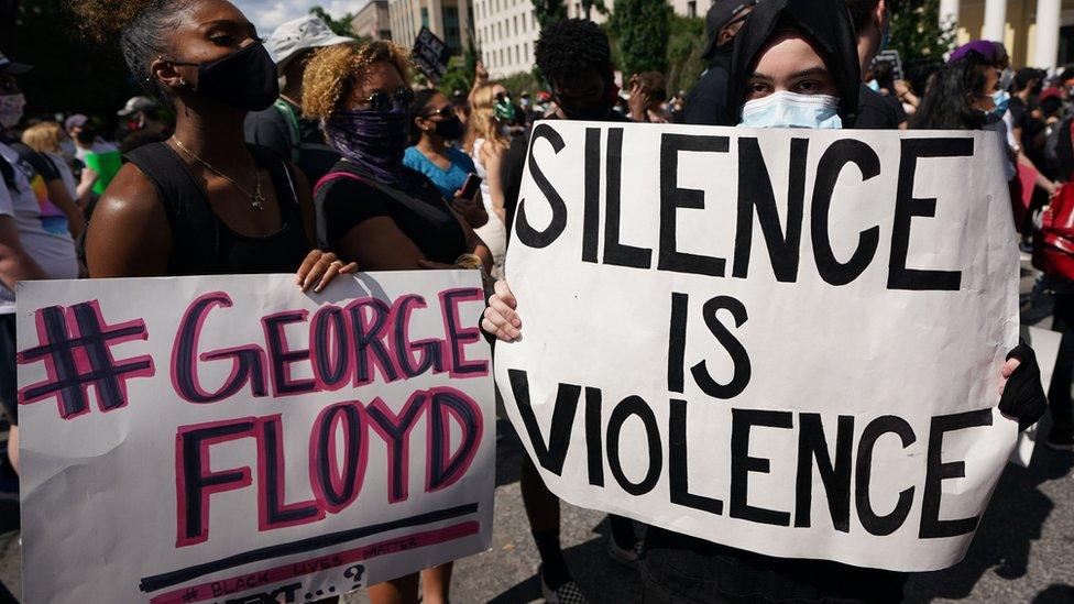 People protesting the death of George Floyd hold up placards in a street near the White House on May 31, 2020 in Washington, DC