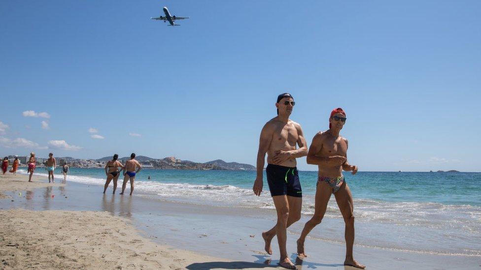 Two men walking along the beach