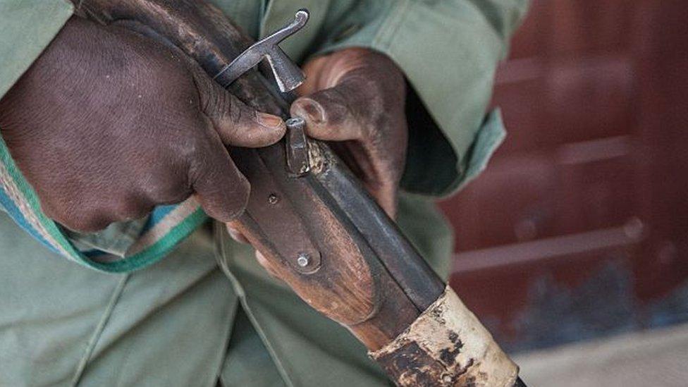 Man holding an old fashioned rifle known as a dane gune