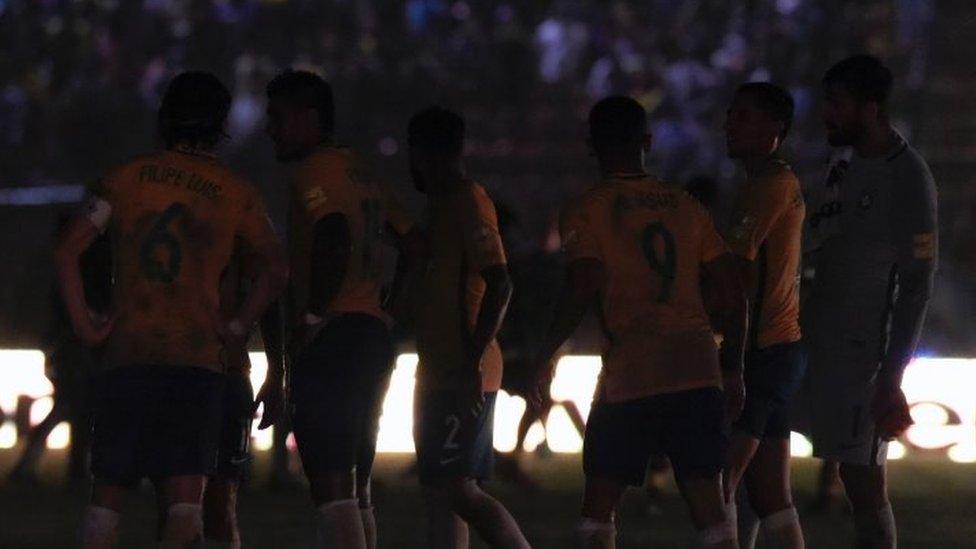 Brazilian players are seen on the field as a blackout occured during the Russia 2018 FIFA World Cup qualifier football match against Venezuela, in Merida, Venezuela, on October 11, 2016.