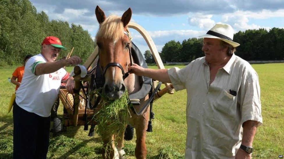 President Lukashenko (left) and Gerard Depardieu lead a horse in the presidential residence near Minsk