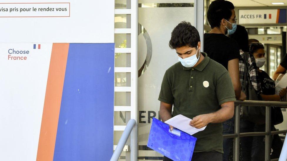 A Tunisian man leaves the offices of TLScontact, a company that works with governments from around the world to provide visa and consular services, after applying for a visa for France, in the capital Tunis, on September 29, 2021