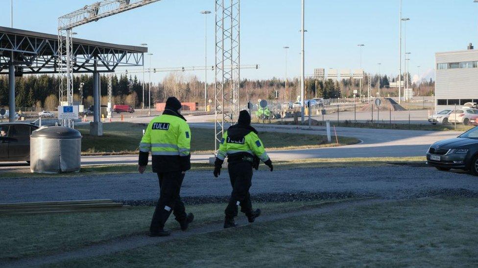 Custom officials walk near the Nuijamaa border crossing station between Finland and Russia, in Lappeenranta, southeastern Finland on November 17, 2023, after the Finnish government announced to close four of its eight eastern border crossings with Russia early on November 18.