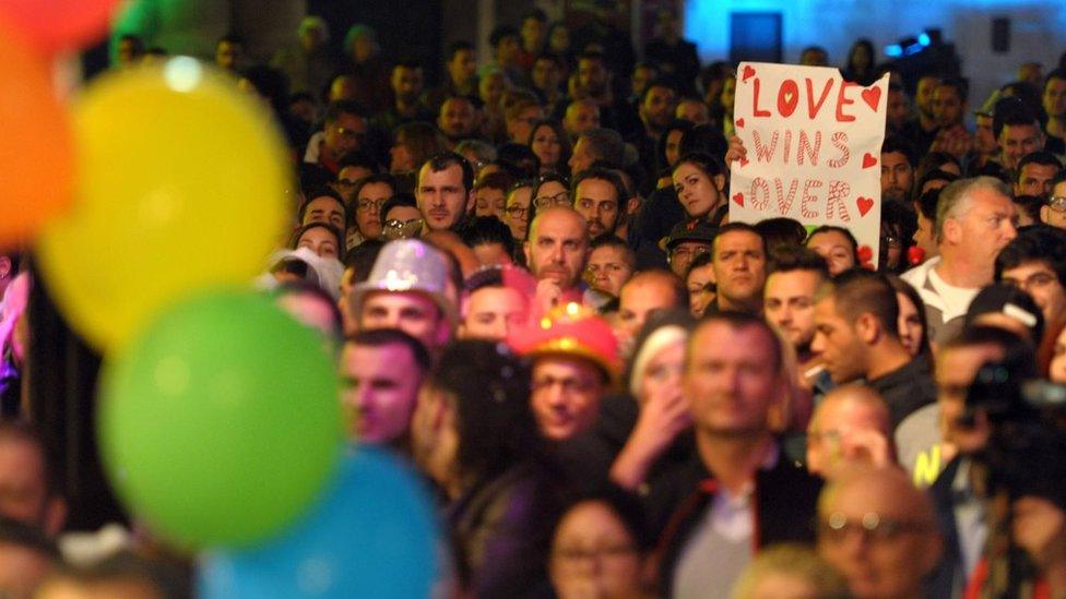 People gather to celebrate in Saint George's Square after the Maltese parliament approved a civil unions bill in Valletta