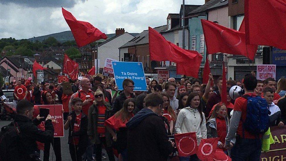 People are marching along the Falls Road into Belfast city centre