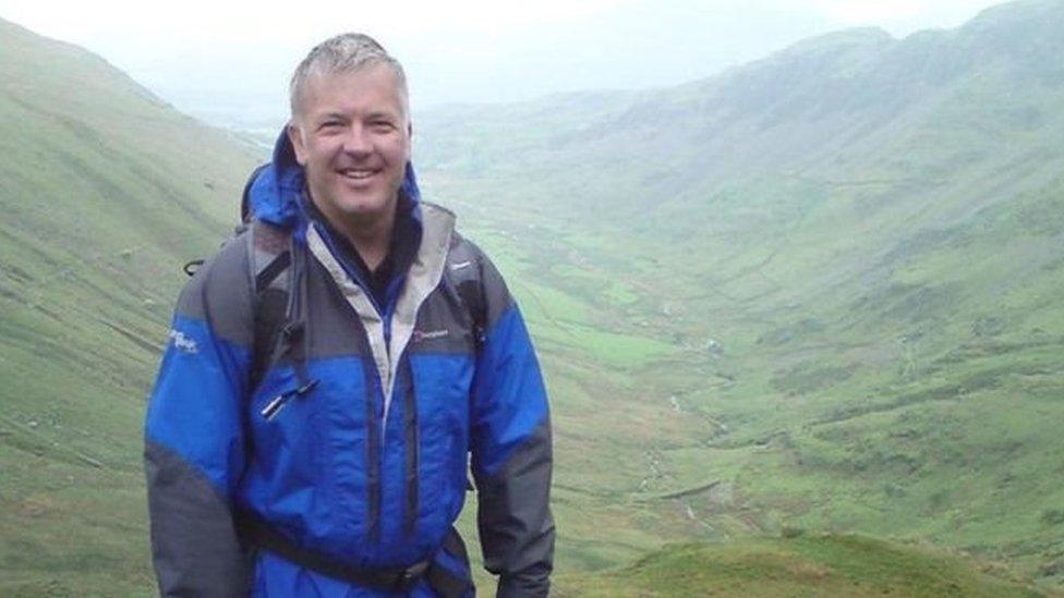 Derek Brockway yn y glaw wrth ffilmio 'Weatherman Walking' i'r BBC