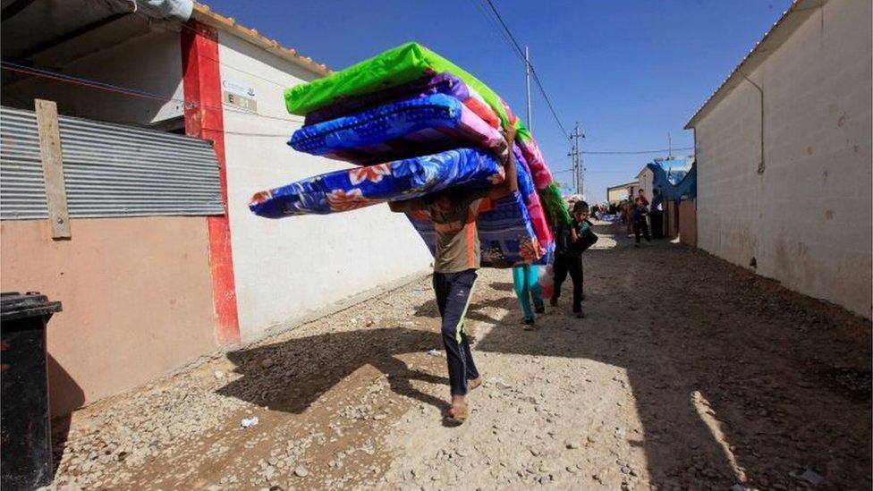 Displaced people who fled Islamic State militants in Mosul receive aid at Deepaka camp in the northwest of Irbil 20 October 2016.