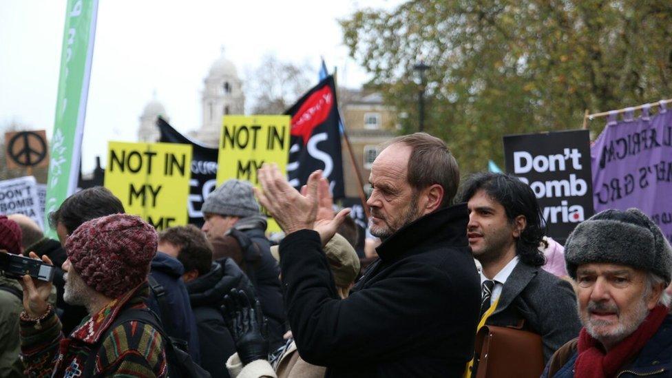 Protesters gathered holding yellow signs which read "Not in my name".