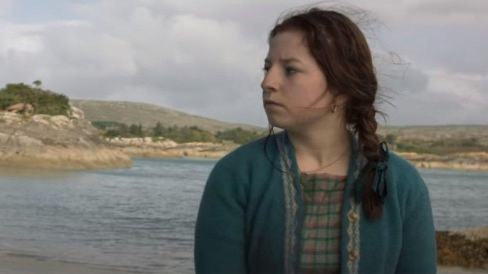 A still from the film Float Like a Butterfly, showing lead actor Hazel Doupe against an outdoor backdrop next to water