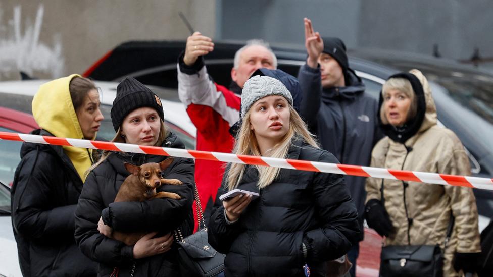 People react at the site of a Russian missile strike in Kyiv