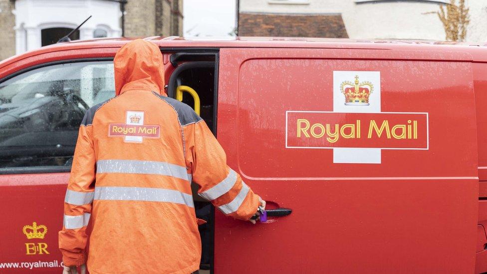 postal worker opening a royal mail van to get packages