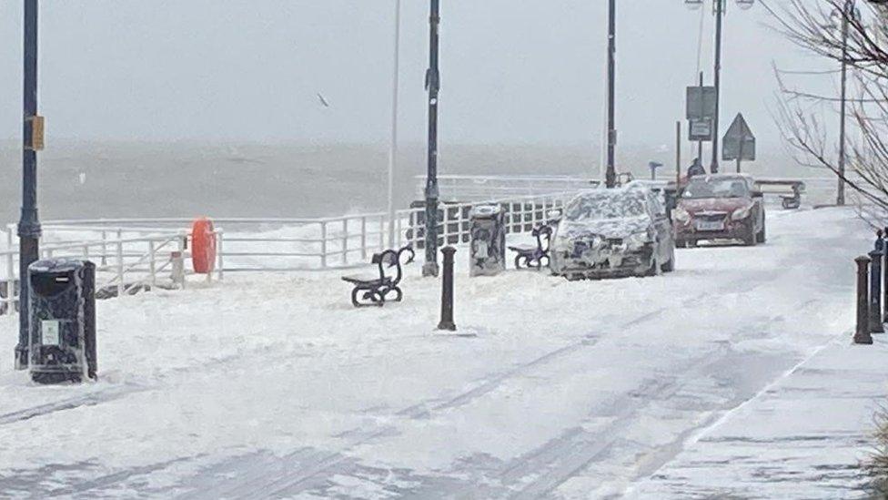 White sea foam covers the road and vehicles