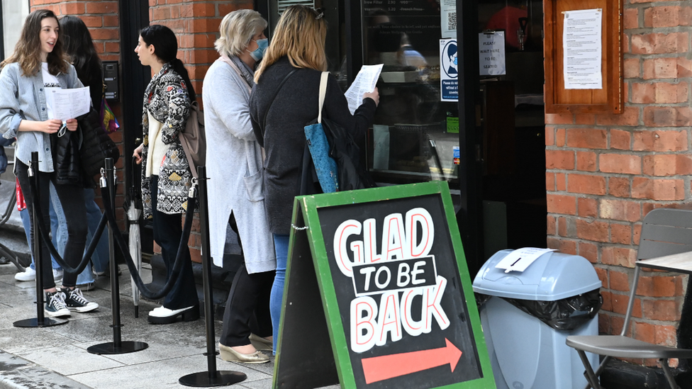 Customers queuing outside a cafe