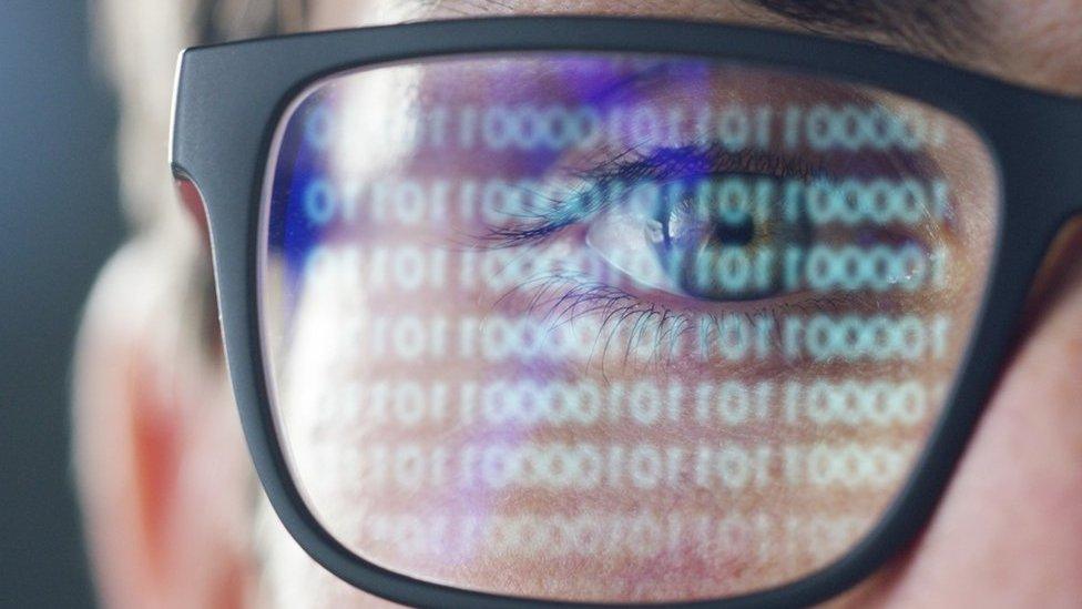 A stock photo of someone examining binary numbers or code