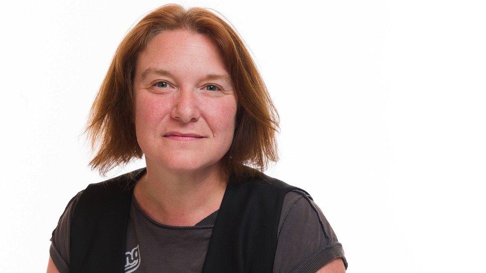 A woman looking at the camera against a white background