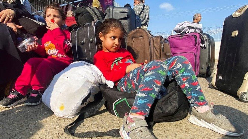 Palestinian children with dual citizenship wait at the Rafah border