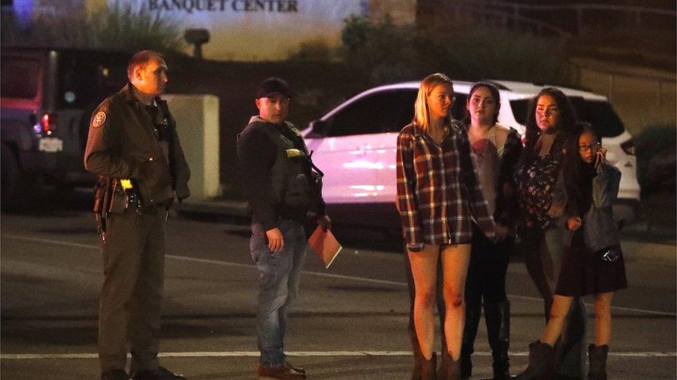 Young girls stand by police