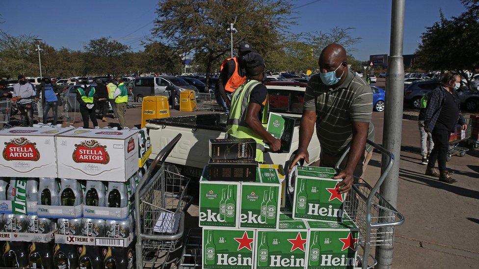 People loading boxes of alcohol into cars