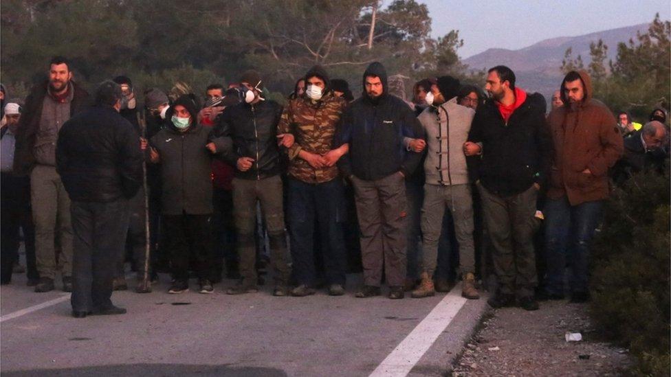 Demonstrators try to block a road in Lesbos