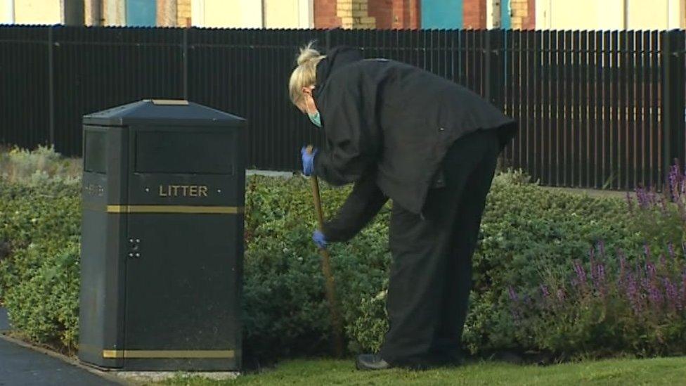 police officer searches bushes