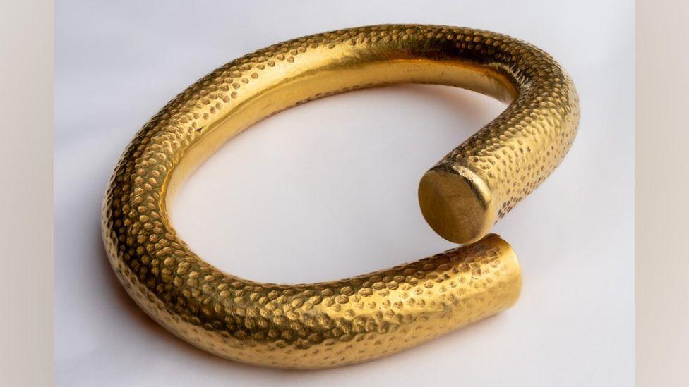 A thick solid gold arm ring, with twisted ends.