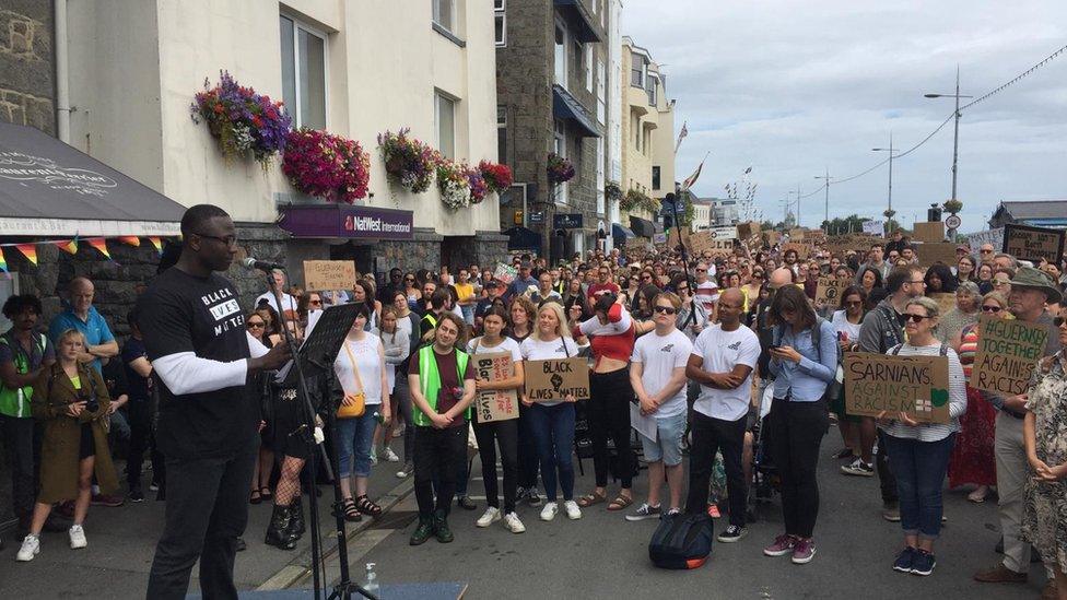 Protesters gathered in front of person speaking