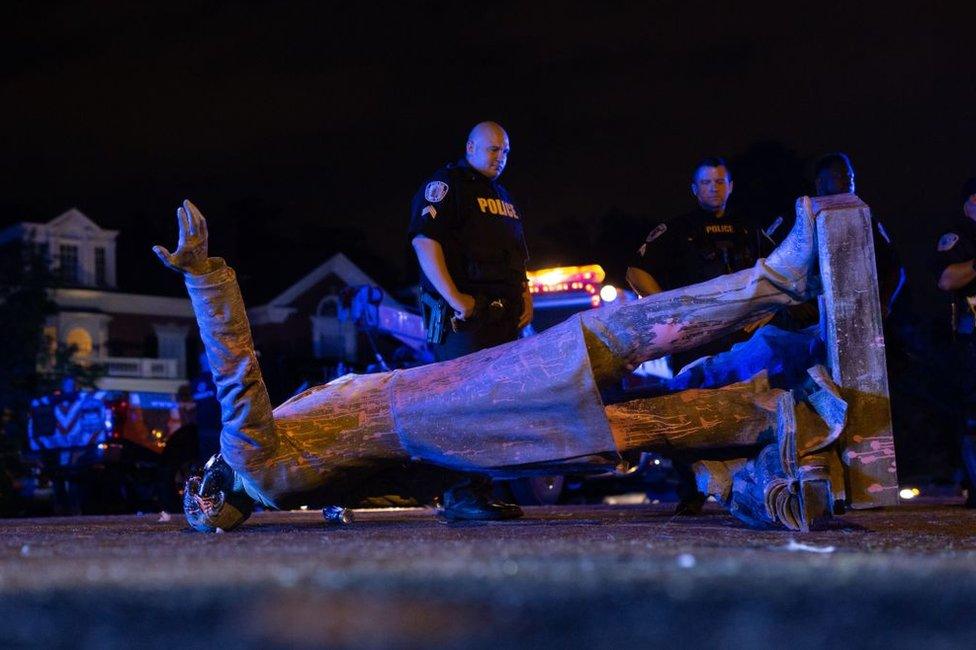 The statue of Jefferson Davis lies on the floor