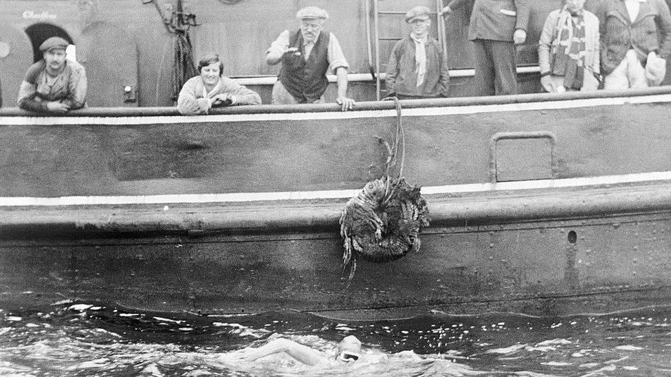 This is one of the first photos to arrive in America from Europe via Quebec, and airplane to New York, showing Gertrude Ederle in her successful Channel swim. This photo shows Margaret Ederle, sister of Trudie, Burgess, and Ishak Helmy, the Egyptian, watching Trudie's progress from the tug Alsace, which accompanied Gertrude across the English Channel on August 6th