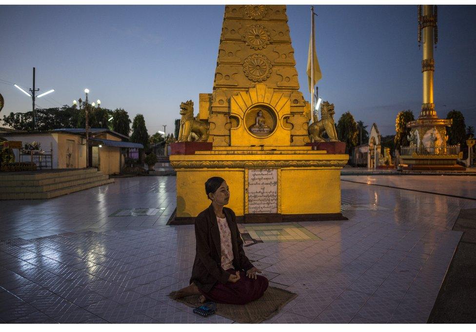 A woman prays at a pagoda in Hinthada, a town in Myanmar's Irrawaddy Delta, just before dawn