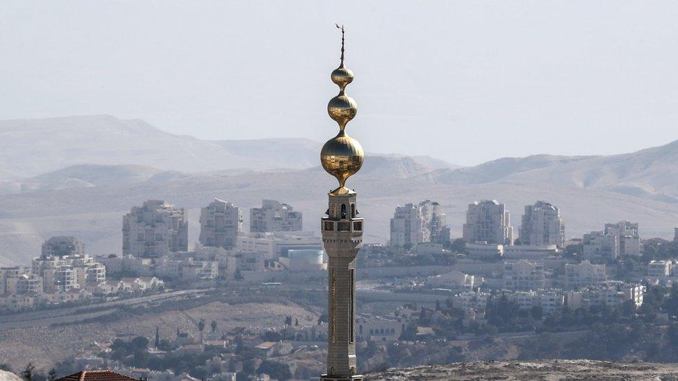 A general view of the mosque of the East Jerusalem neighbourhood of Issawiya and the Israeli West Bank settlement of Maale Adumim in the background, 19 November 2019