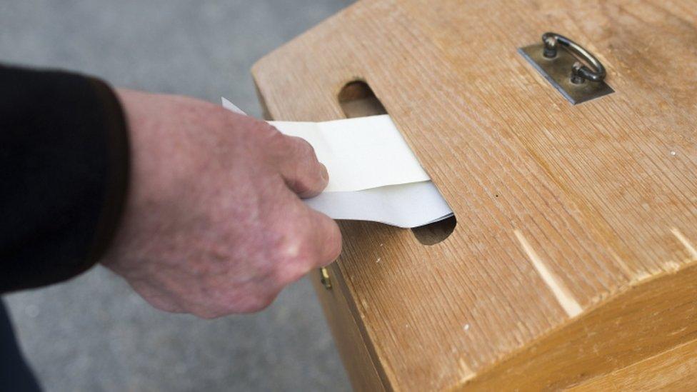 A voter places their ballot