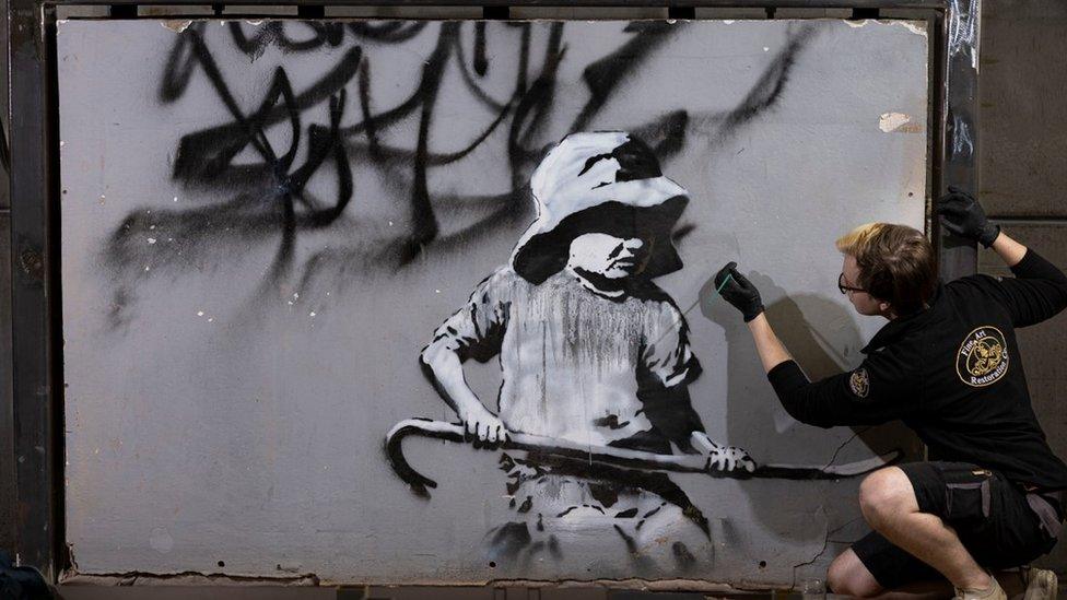 Conservator working on the Banksy restoration