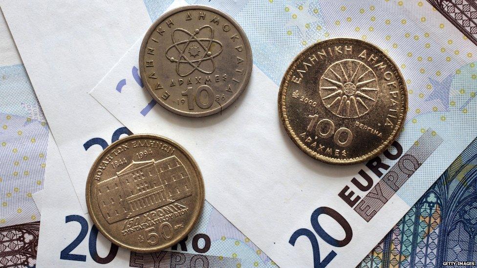 Greek drachma coins sit on euro notes