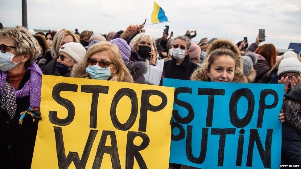 A photo of protesters in Italy holding 'stop war, stop Putin signs'