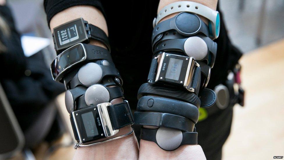 Arms covered in fitness devices.