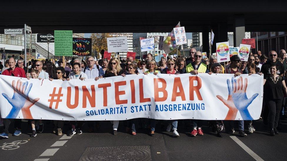 Marchers carry "#indivisible" banner