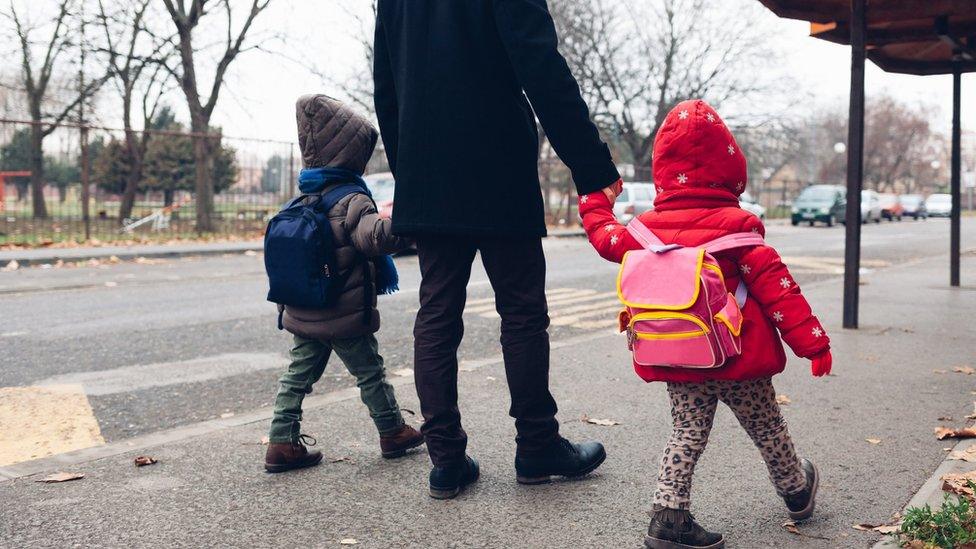 Man walking children to school