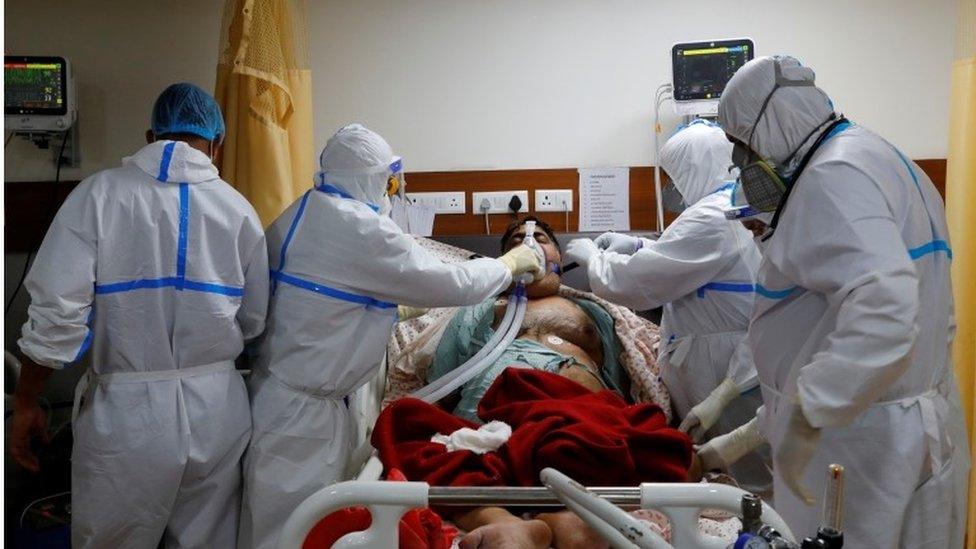 Medical workers take care of a patient suffering from the coronavirus disease at the ICU of the Yatharth Hospital in Noida.