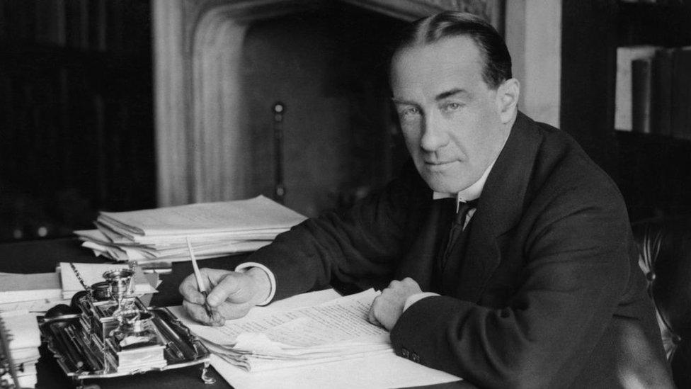 Stanley Baldwin sitting at a desk