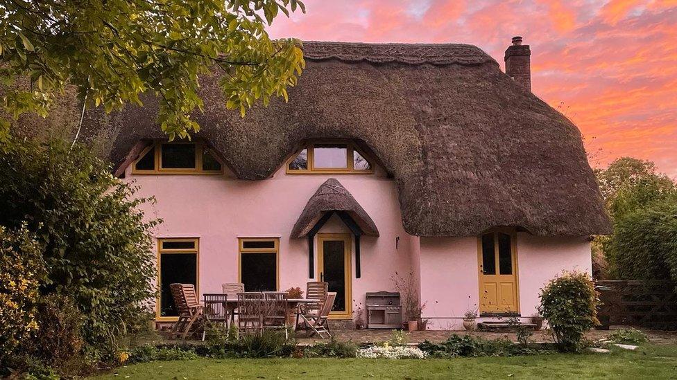 Exterior of thatched house at sunrise