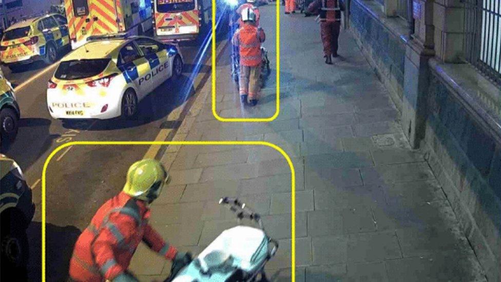 members of the Greater Manchester Fire and Rescue Service moving empty stretchers along Station Approach towards the entrance of Victoria Train Station, following the Manchester Arena terror attack