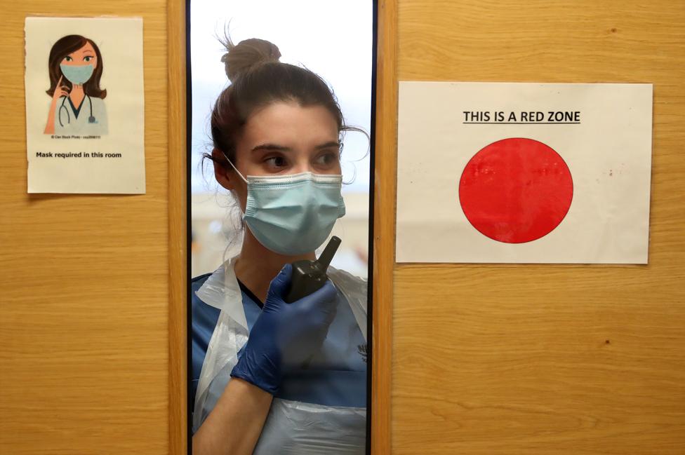 A nurse uses a walkie-talkie