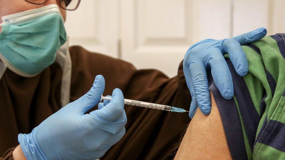 A dose of Covid vaccine is administered to a woman at a vaccination centre in October