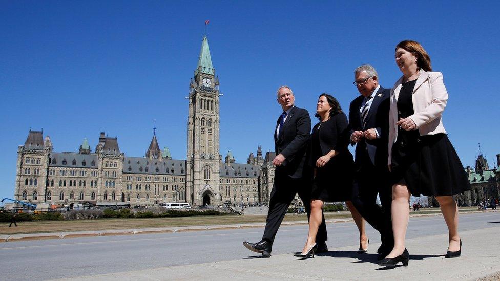 Canadian politicians walk across Parliament Hill