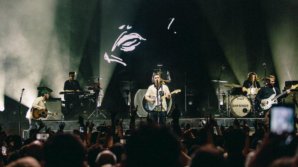 Sam Fender on stage with his band