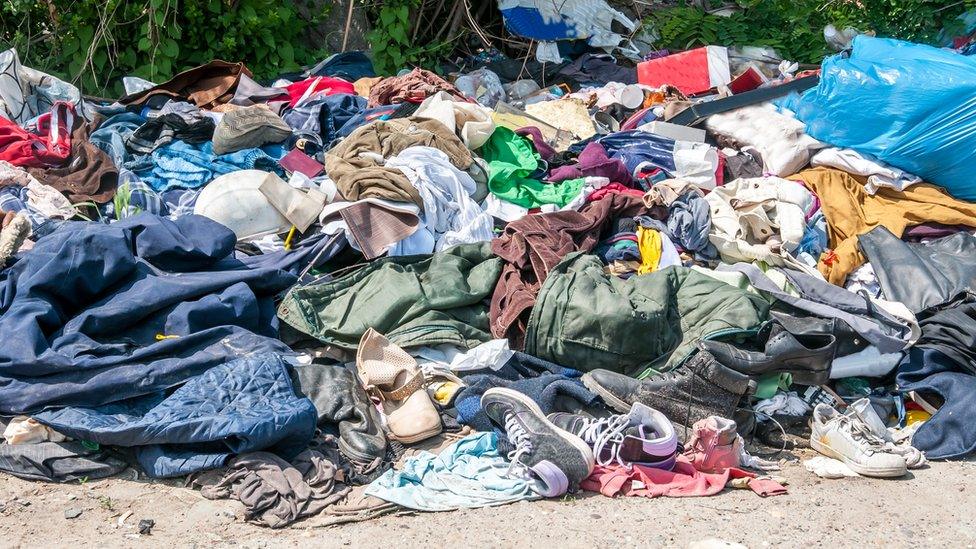 Discarded clothes on a rubbish pile.