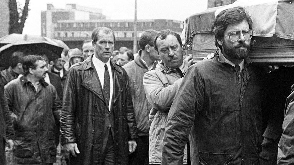 Freddie Scappaticci in the background as Gerry Adams carries a coffin at a republican funeral