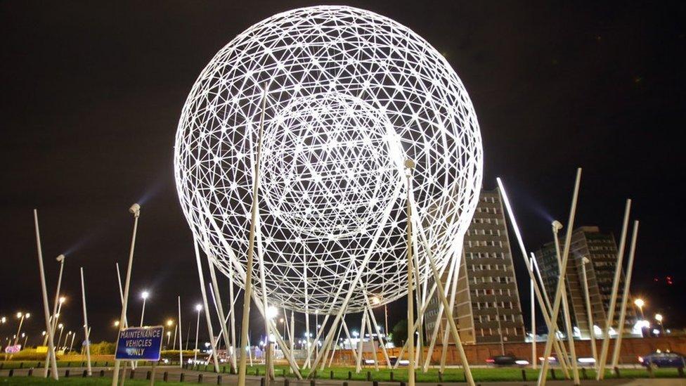 Spherical metal sculpture at night