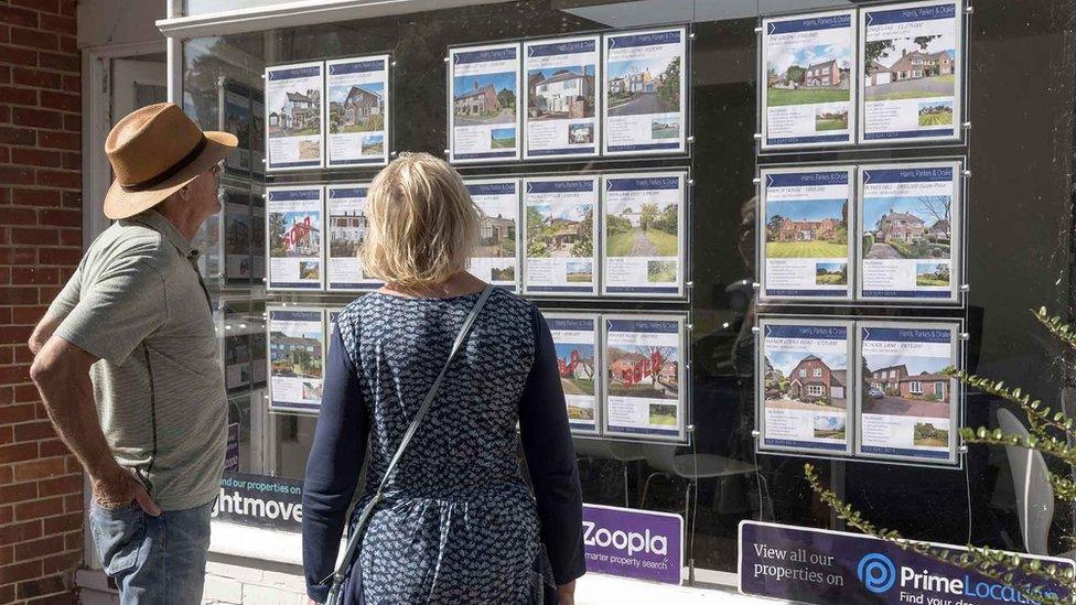 Couple looking in an estate agents' window